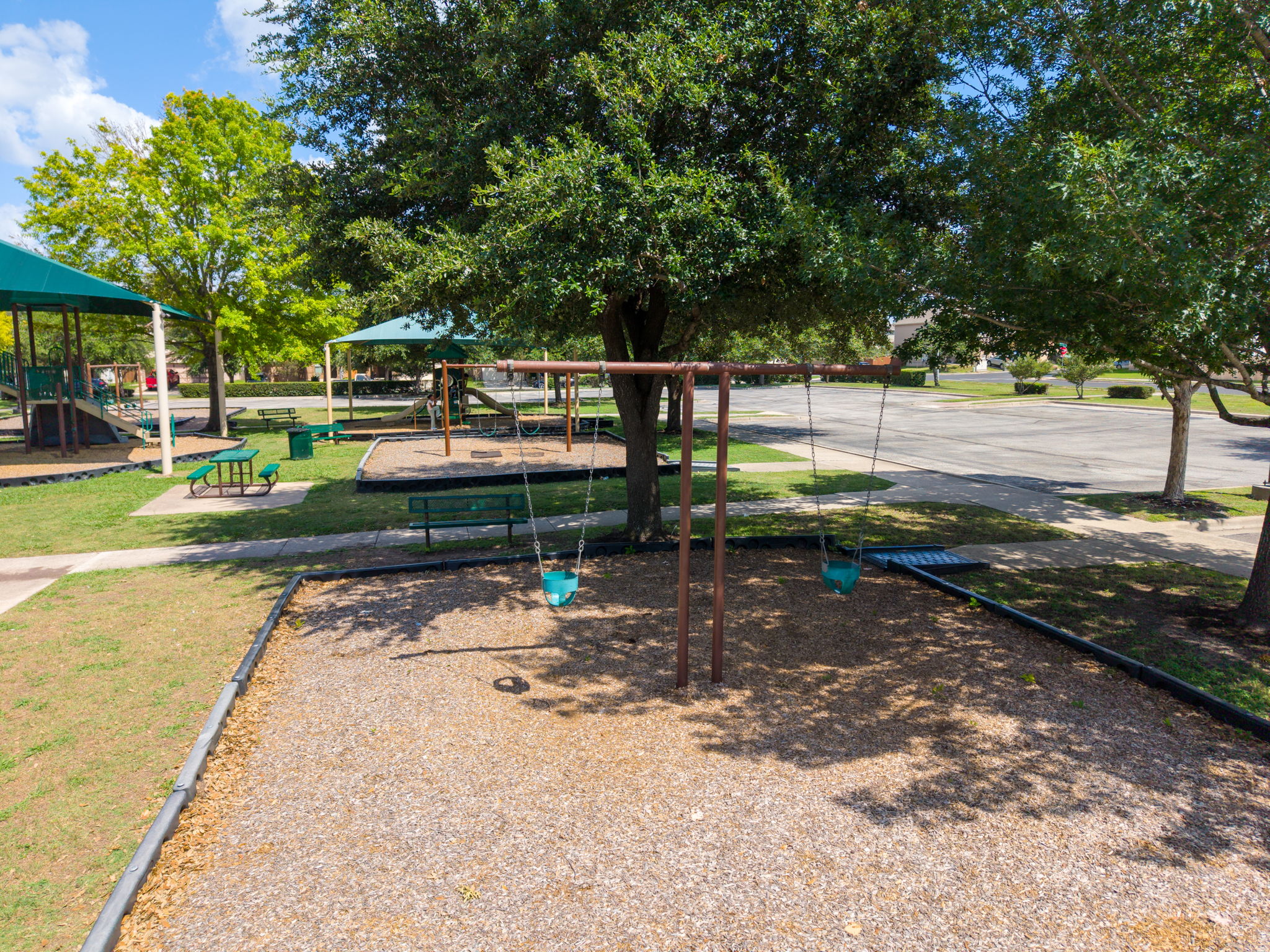 8813 Wiley Way Austin, TX 78747 - Photo 38 of 39 A well-maintained community park with multiple play structures and mature shade trees.