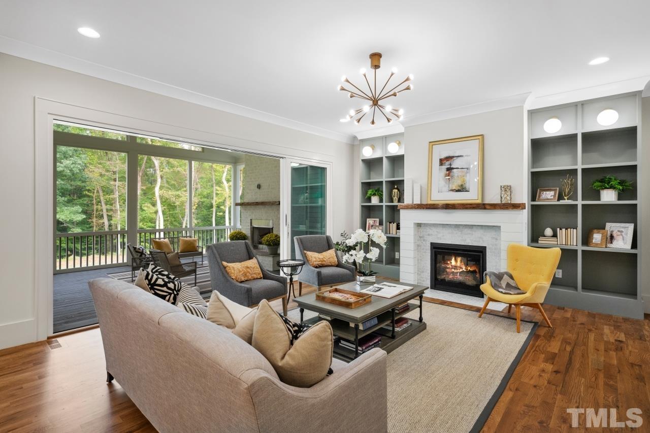 7204 Sing Along Court Raleigh, NC 27613 - Photo 18 of 46 a living room with furniture a fireplace and a floor to ceiling window