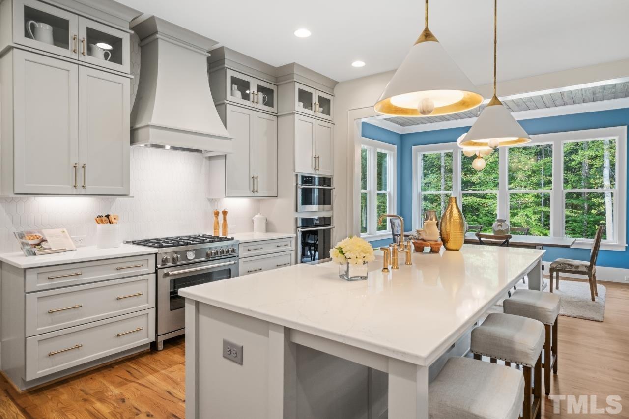 7204 Sing Along Court Raleigh, NC 27613 - Photo 25 of 46 a kitchen with a stove a refrigerator and a dining table