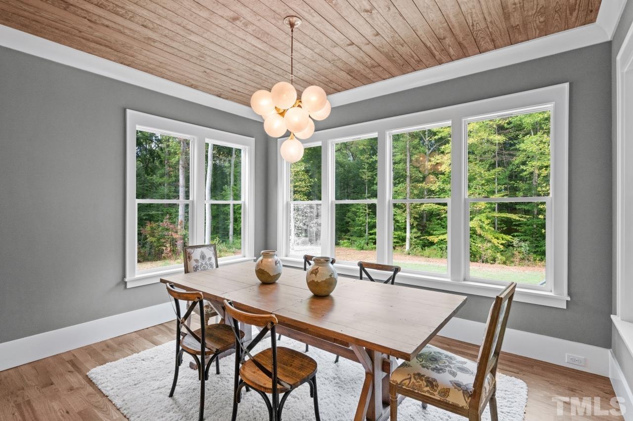 7204 Sing Along Court Raleigh, NC 27613 - Photo 26 of 46 a view of a dining room with furniture large windows and wooden floor