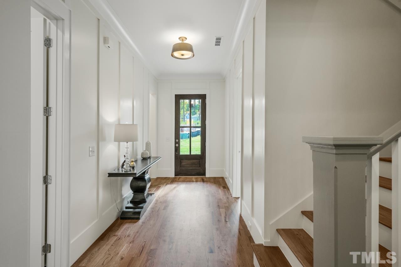 7204 Sing Along Court Raleigh, NC 27613 - Photo 4 of 46 a view of a hallway with wooden floor and a living room