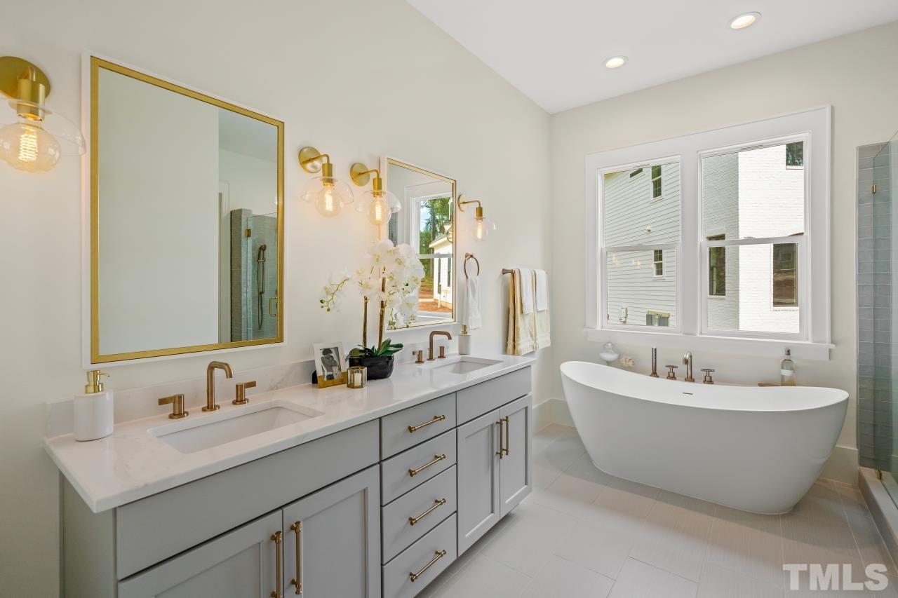 7204 Sing Along Court Raleigh, NC 27613 - Photo 6 of 46 a spacious bathroom with a double vanity sink mirror and bathtub