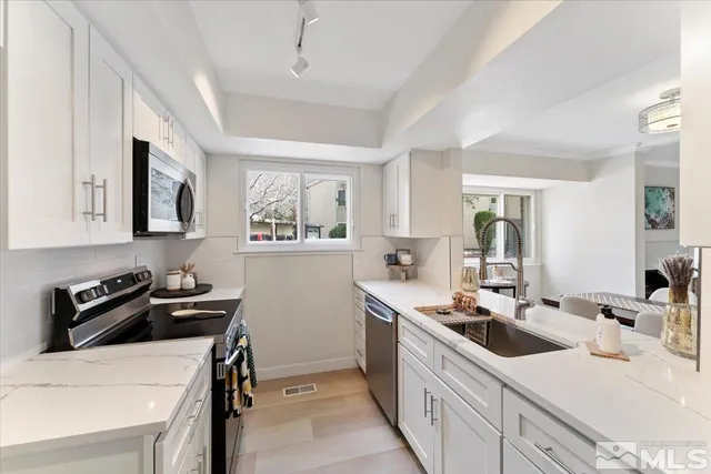 a kitchen that has a sink and a stove in it