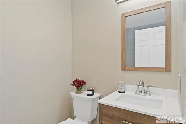 a bathroom with a sink mirror and a toilet