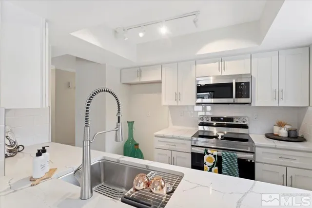 a kitchen with stainless steel appliances kitchen island granite countertop a stove and a sink with granite countertops