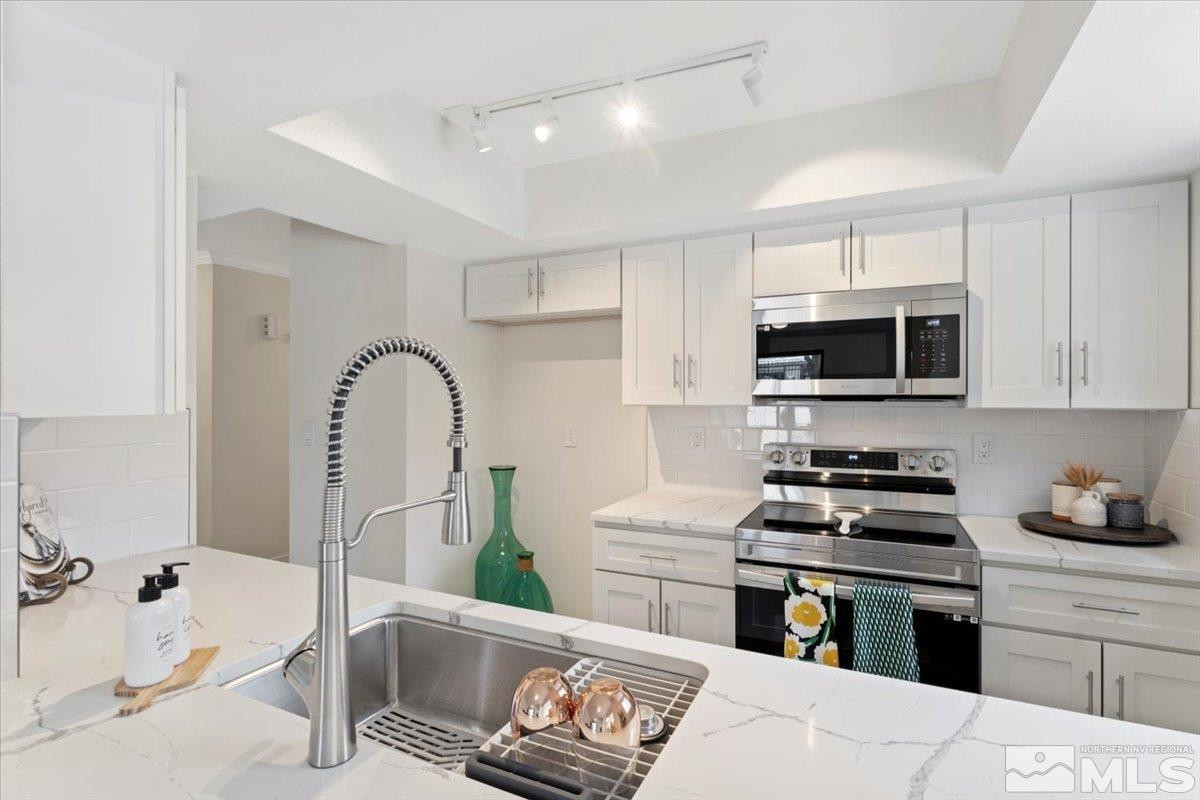 2380 Roundhouse Road Sparks, NV 89431 - Photo 3 of 22 a kitchen with stainless steel appliances kitchen island granite countertop a stove and a sink with granite countertops