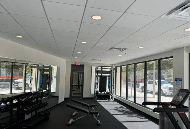 a room with gym equipment and large windows