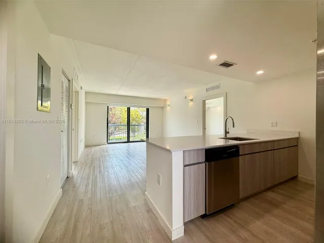 a large kitchen with wooden floor and cabinets