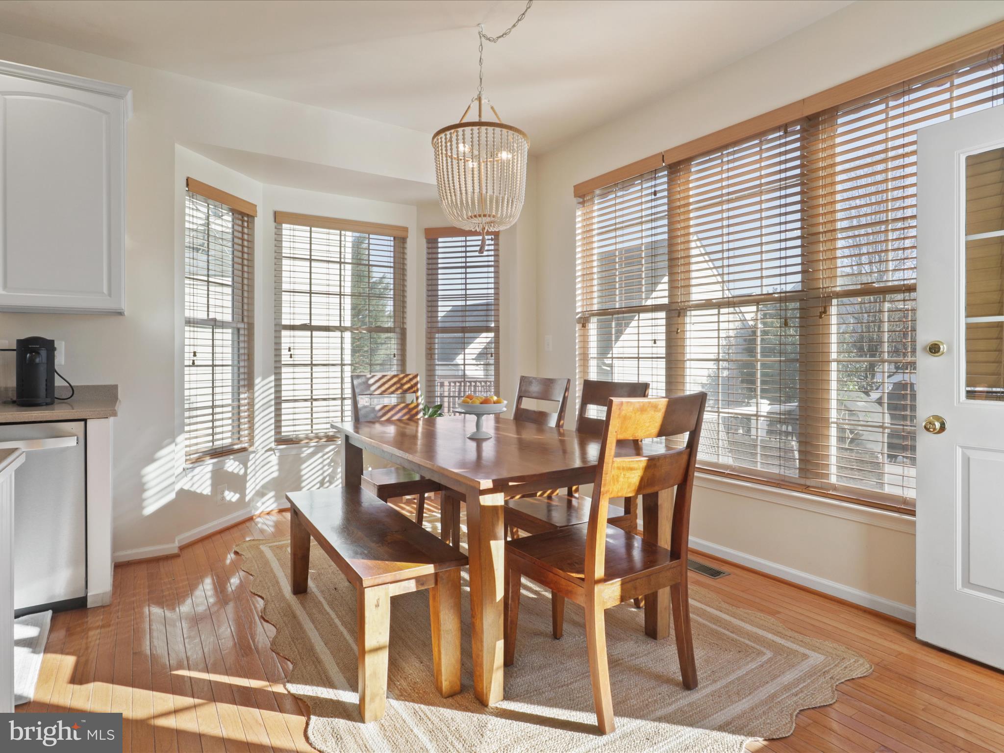 43081 Edgewater Street Chantilly, VA 20152 - Photo 13 of 50 a view of a dining room with furniture wooden floor and a rug
