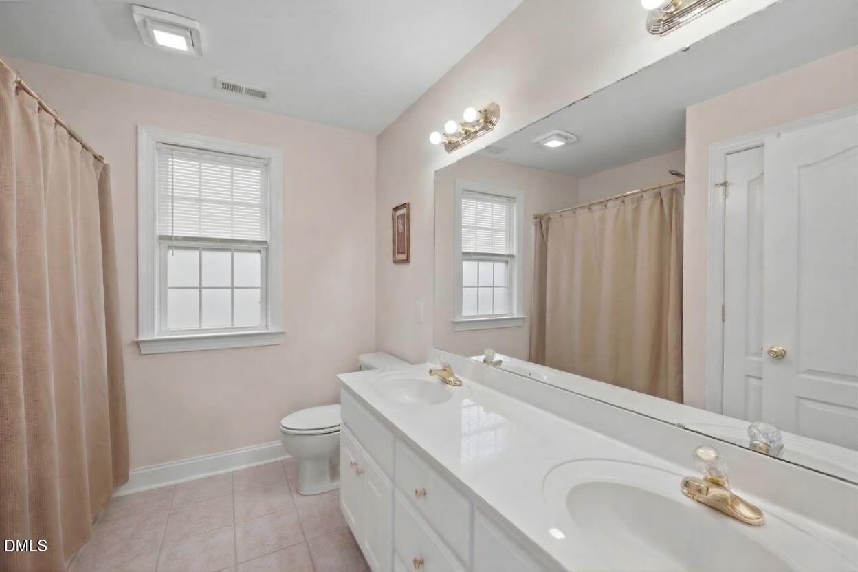 226 Marshview Circle Angier, NC 27501 - Photo 9 of 20 a spacious bathroom with a double vanity sink toilet and a mirror
