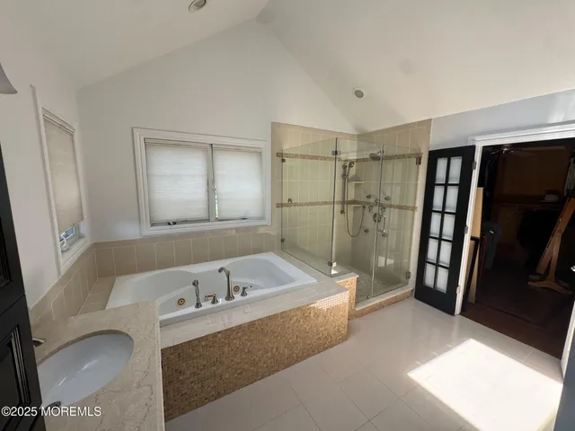 a bathroom with a tub a sink and a large mirror