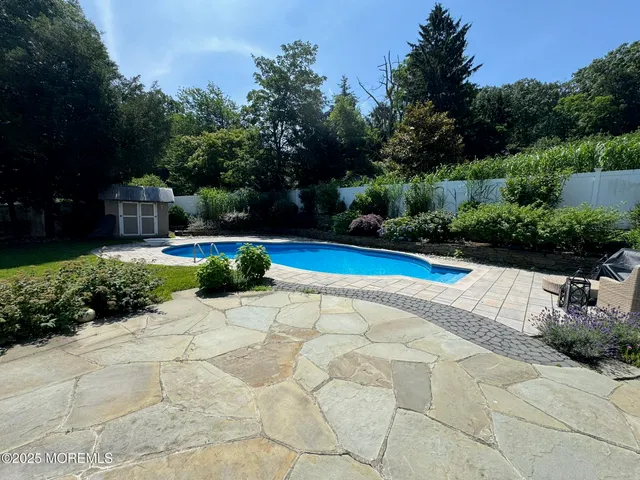a view of backyard with swimming pool and green space