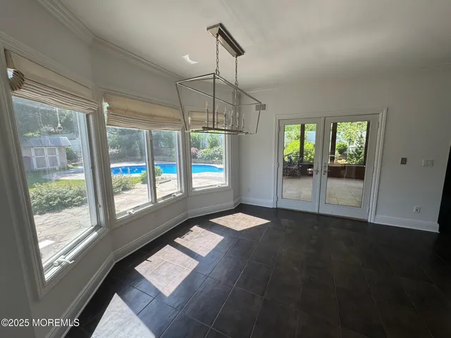 a view of an empty room with glass door and windows