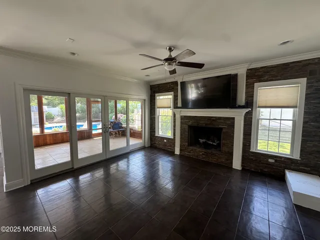 a view of an empty room with wooden floor and a fireplace