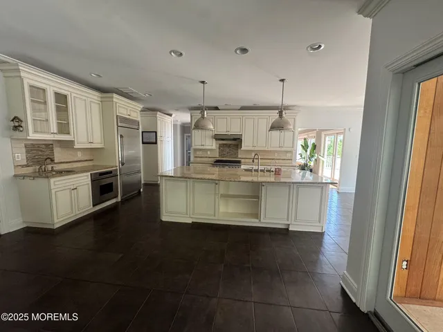 a kitchen with stainless steel appliances granite countertop a stove a sink and a refrigerator