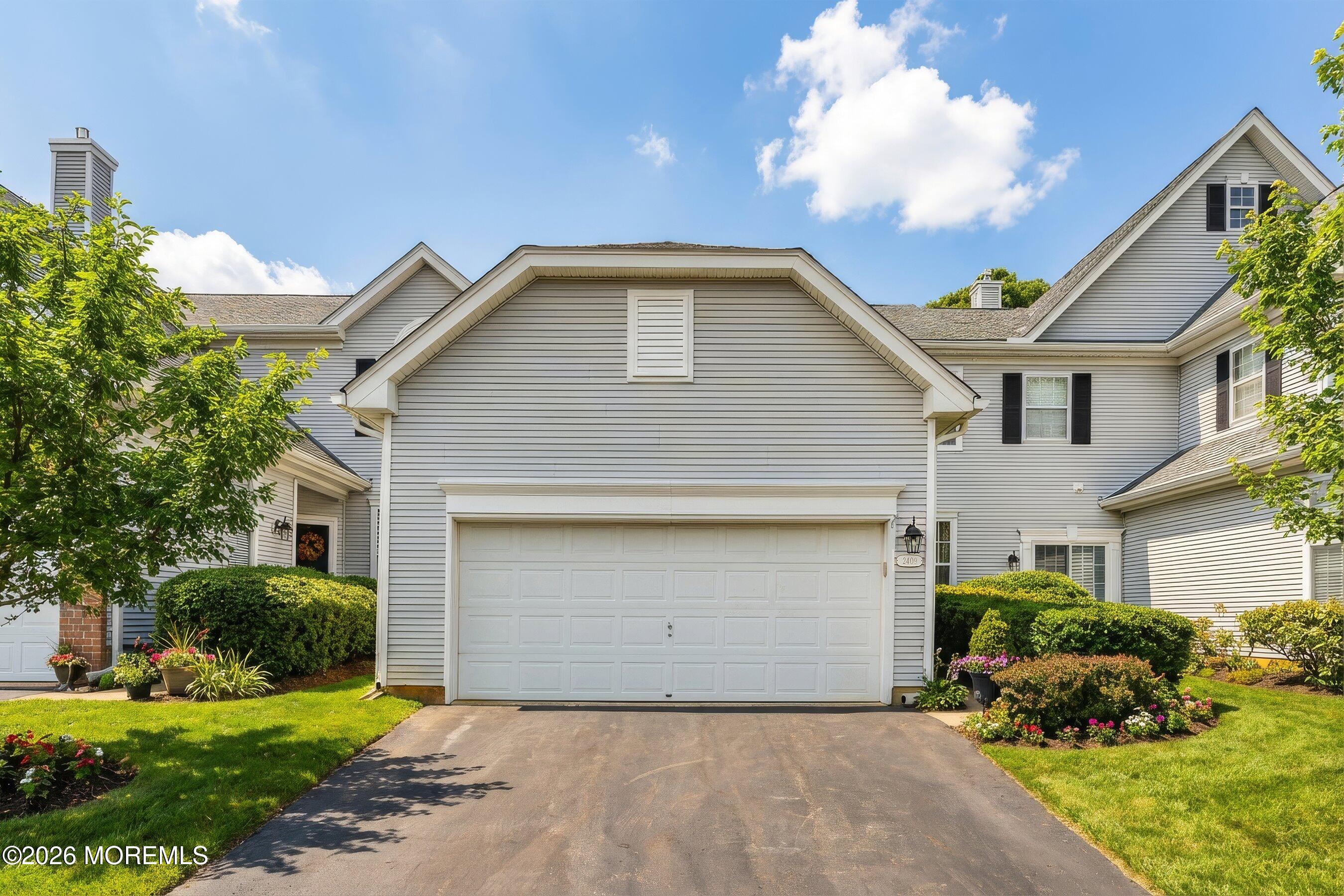 2409 Robin Way Manasquan, NJ 08736 - Photo 23 of 40 a front view of a house with a yard and garage