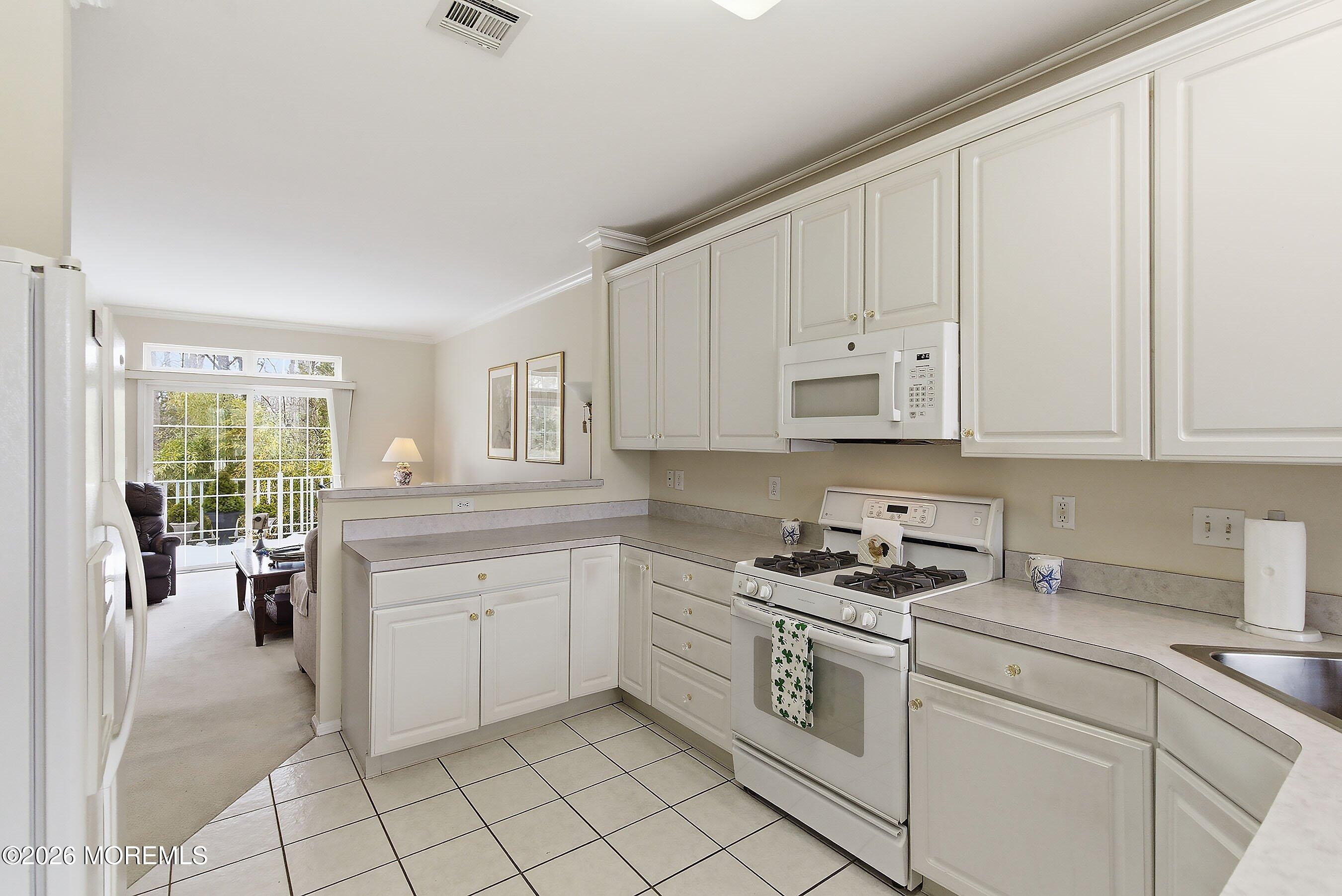 2409 Robin Way Manasquan, NJ 08736 - Photo 8 of 40 a kitchen with cabinets appliances a sink and a window