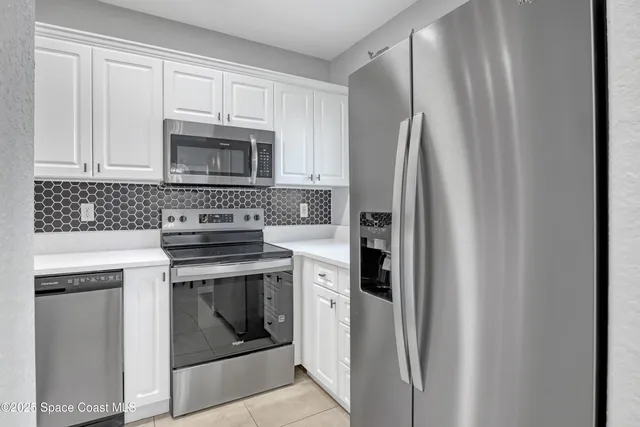a kitchen with white cabinets and appliances