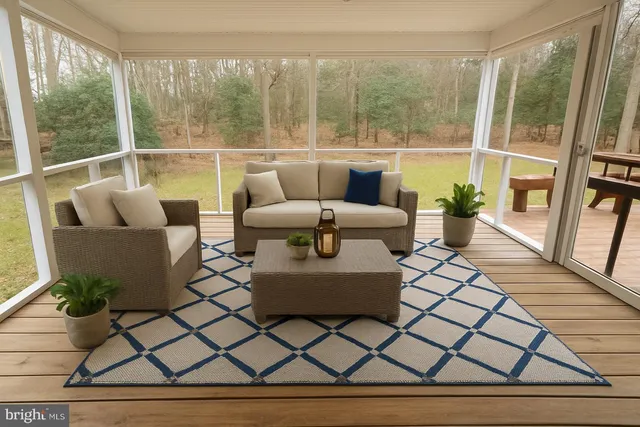 a living room with patio furniture and a large window