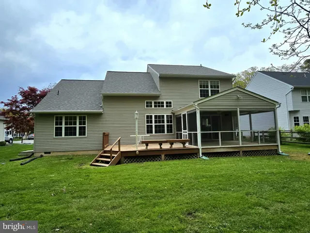 a front view of a house with a garden and trees