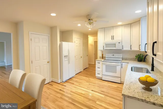 a spacious bathroom with a granite countertop sink and a mirror