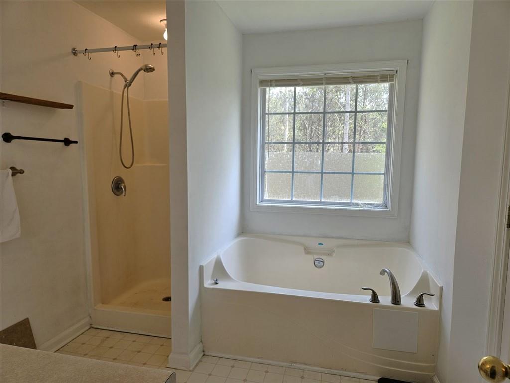 80 Jacob Trail Rockmart, GA 30153 - Photo 14 of 24 a bathroom with a bathtub a shower and a window