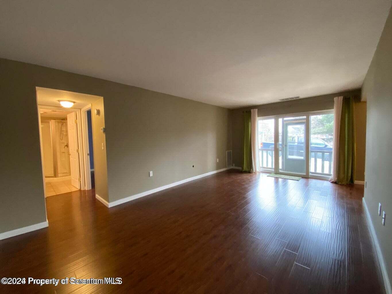 1702 Summit Pointe Scranton, PA 18508 - Photo 11 of 30 a view of an empty room with glass door and wooden floor