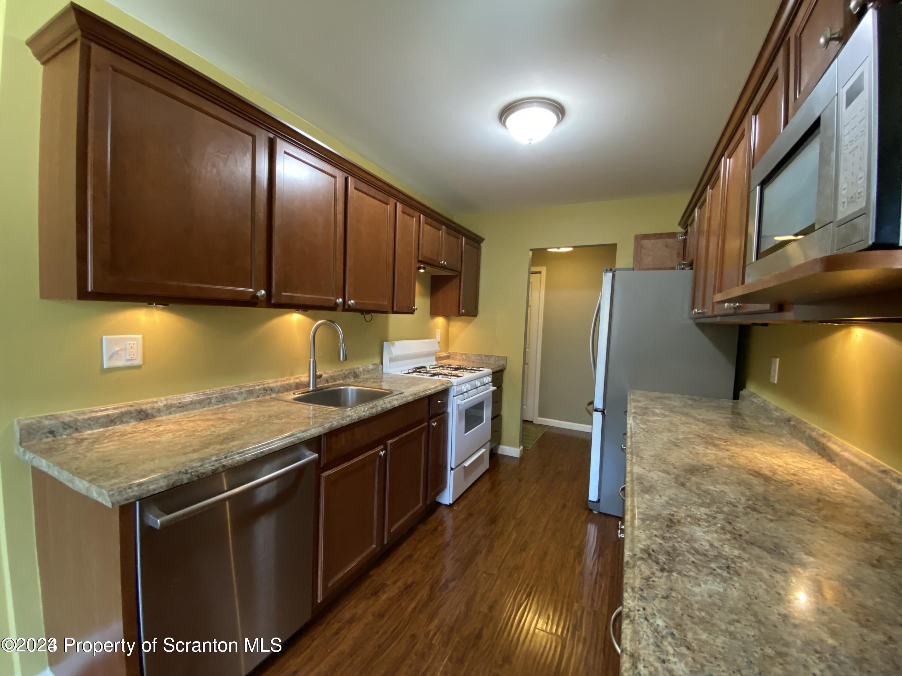 1702 Summit Pointe Scranton, PA 18508 - Photo 7 of 30 a kitchen with stainless steel appliances granite countertop a stove a sink and a refrigerator