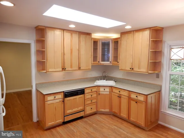 a kitchen with a sink window and cabinets