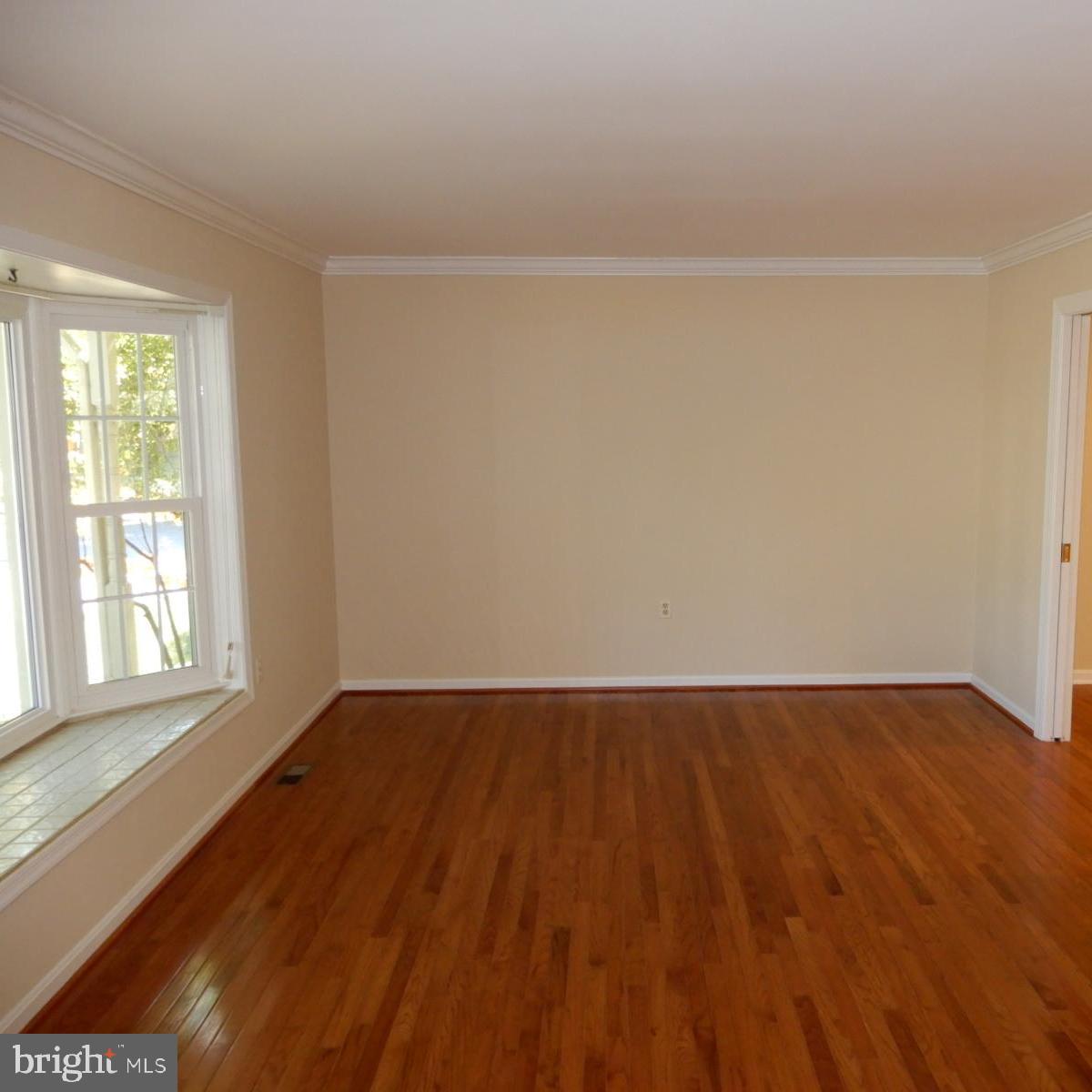 7014 Maple Tree Lane Springfield, VA 22152 - Photo 4 of 56 an empty room with wooden floor and windows