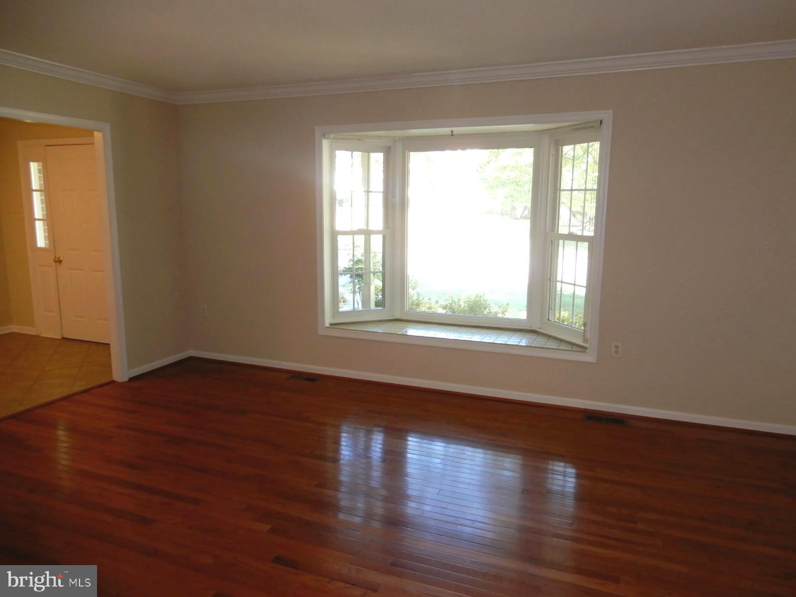 7014 Maple Tree Lane Springfield, VA 22152 - Photo 5 of 56 a view of an empty room with wooden floor and a window