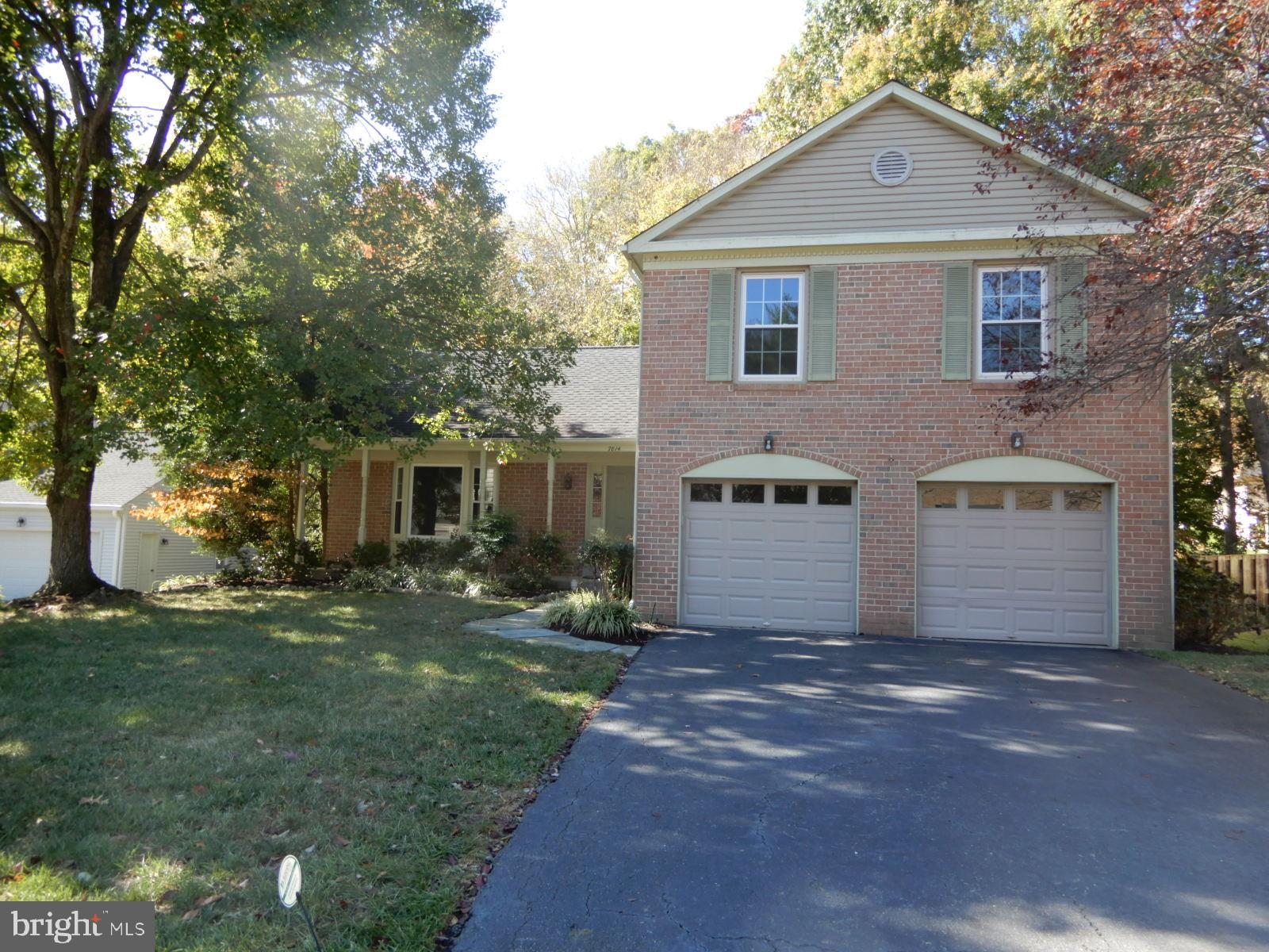 7014 Maple Tree Lane Springfield, VA 22152 - Photo 56 of 56 a front view of a house with a yard and garage