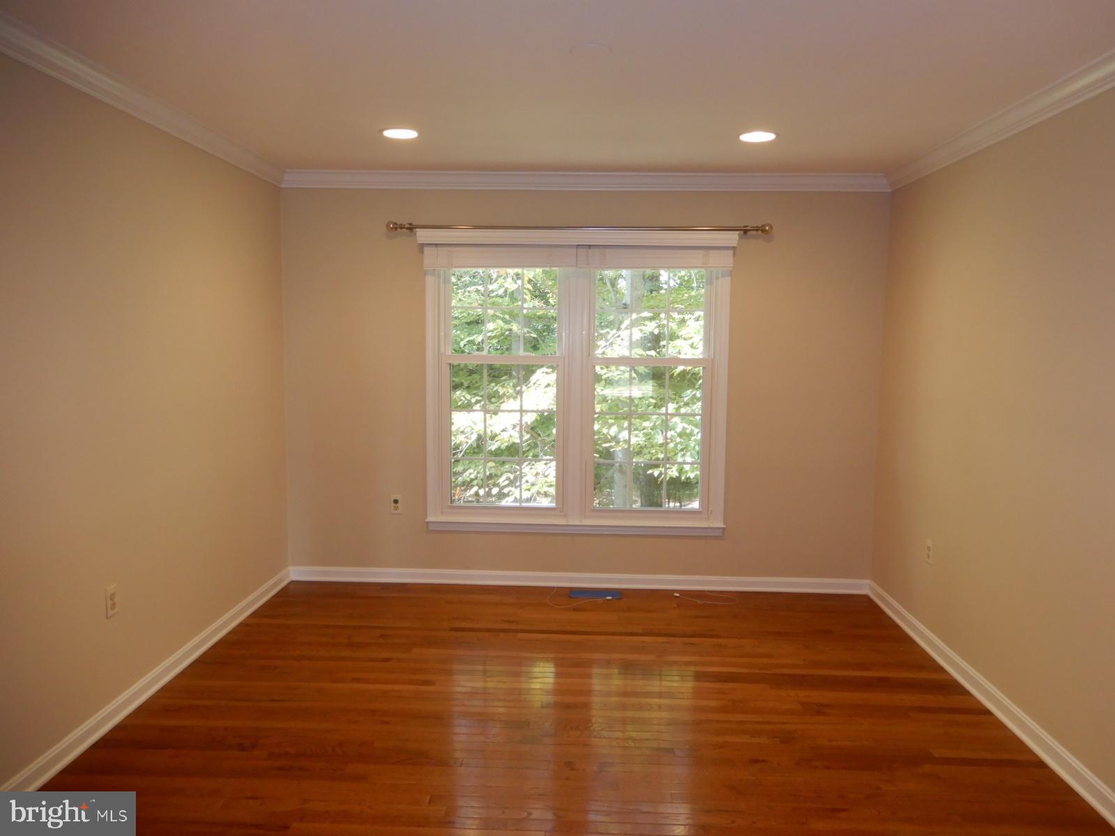 7014 Maple Tree Lane Springfield, VA 22152 - Photo 7 of 56 an empty room with wooden floor and windows