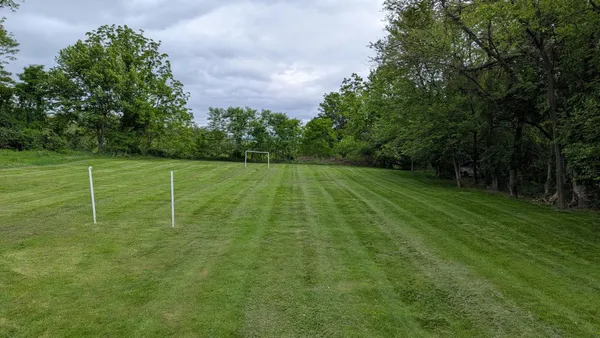a view of a field with trees in the background