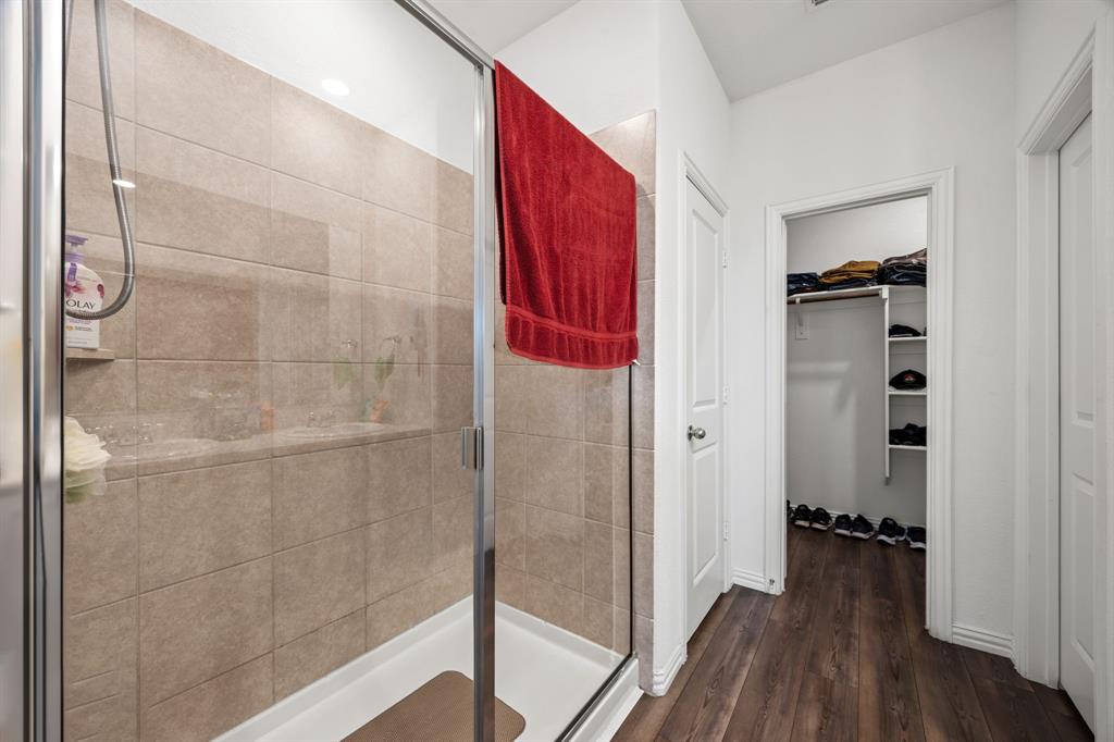 753 Lombard Lane Forney, TX 75126 - Photo 22 of 25 Full bathroom featuring a stall shower, wood finished floors, and a spacious closet