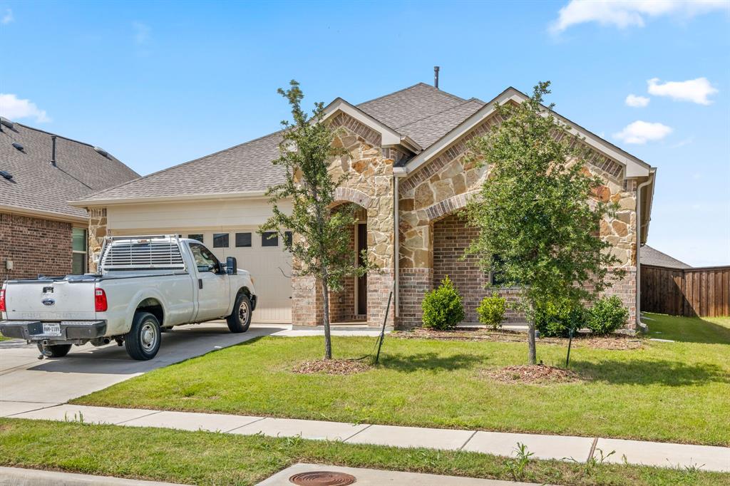 753 Lombard Lane Forney, TX 75126 - Photo 3 of 25 View of front of home featuring stone siding, concrete driveway, an attached garage, and a shingled roof