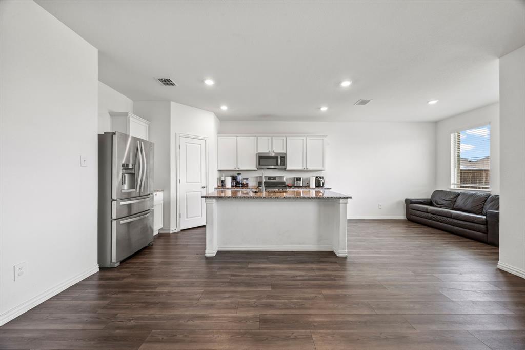 753 Lombard Lane Forney, TX 75126 - Photo 25 of 25 Kitchen with stainless steel appliances, open floor plan, recessed lighting, dark wood-style flooring, and white cabinetry