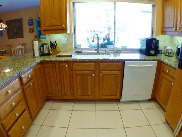 827 Northeast 33rd Street Boca Raton, FL 33431 - Photo 11 of 25 a kitchen with sink a window and cabinets