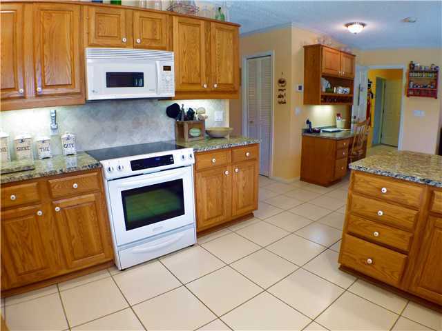 827 Northeast 33rd Street Boca Raton, FL 33431 - Photo 12 of 25 a kitchen with stainless steel appliances granite countertop a stove a sink and a refrigerator