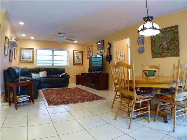 827 Northeast 33rd Street Boca Raton, FL 33431 - Photo 15 of 25 a living room with furniture a dining table and a chandelier