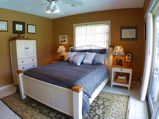 827 Northeast 33rd Street Boca Raton, FL 33431 - Photo 21 of 25 a bedroom with a bed and a chandelier