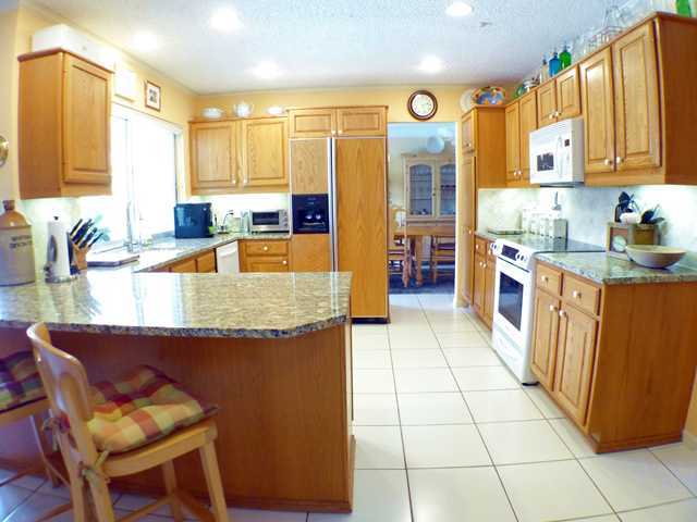 827 Northeast 33rd Street Boca Raton, FL 33431 - Photo 9 of 25 a kitchen with stainless steel appliances granite countertop a stove top oven a sink dishwasher and cabinets with wooden floor