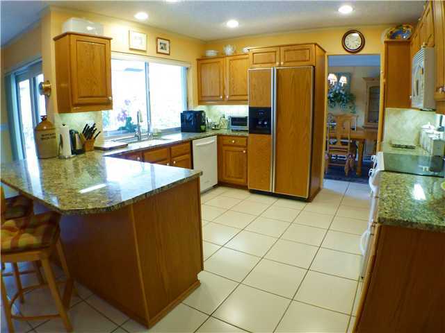 827 Northeast 33rd Street Boca Raton, FL 33431 - Photo 10 of 25 a kitchen with stainless steel appliances granite countertop a sink and a refrigerator