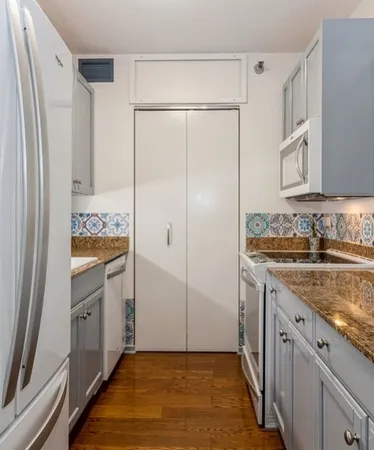 a bathroom with a granite countertop sink a mirror and a shower