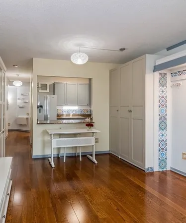 a living room with kitchen view and wooden floor