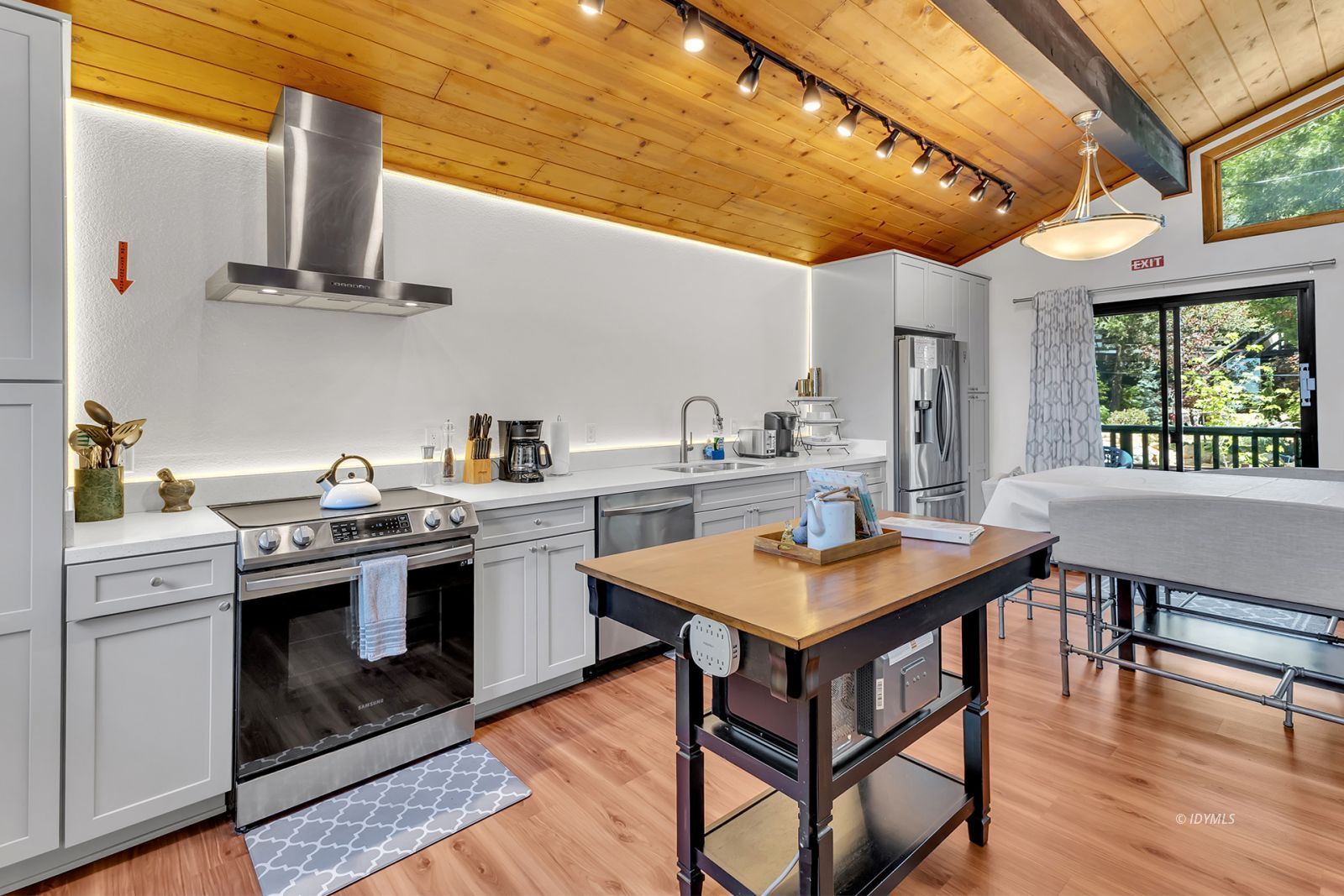 25595 Glen Road Idyllwild, CA 92549 - Photo 25 of 51 a kitchen with stainless steel appliances a stove a sink dishwasher a dining table and chairs with wooden floor