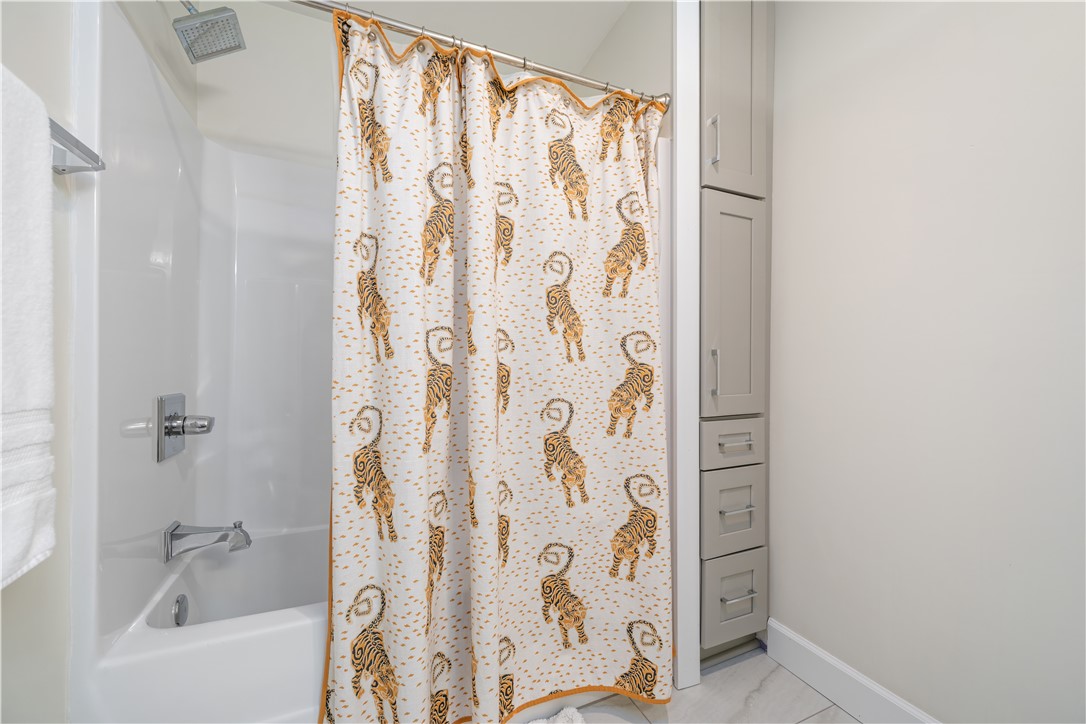 640 Old Salem Road Seneca, SC 29672 - Photo 17 of 32 This bathroom features a shower with a vibrant curtain and convenient built-in storage.