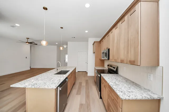 a kitchen with stainless steel appliances granite countertop a sink stove and refrigerator