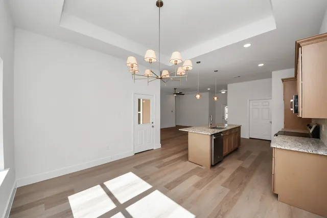 a large kitchen with granite countertop a stove a sink a window and a dining table