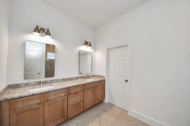 a spacious bathroom with a granite countertop sink and a mirror